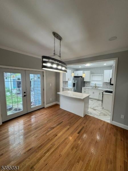 385 Stiles St, Union Twp, NJ 07088 - kitchen with stainless steel fridge, white cabinetry, ornamental molding, light wood finished floors, and light countertops