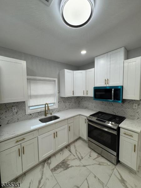 385 Stiles St, Union Twp, NJ 07088 - kitchen featuring stainless steel appliances, a sink, light marble finish floors, white cabinetry, and recessed lighting
