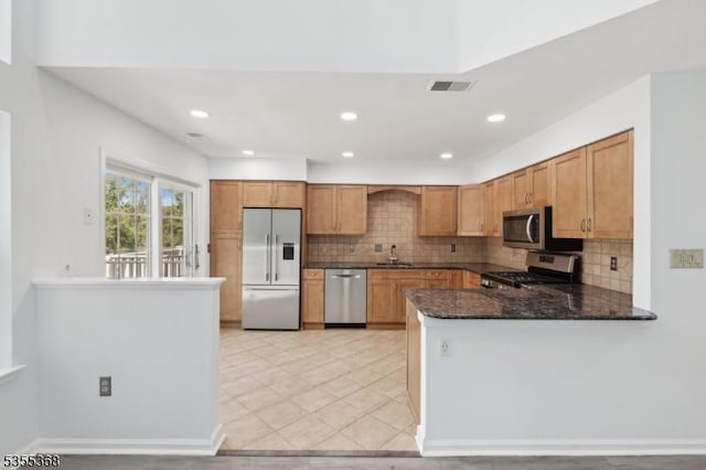 4703 Patterson St, Bridgewater Twp, NJ 08807 - kitchen with stainless steel appliances, a sink, tasteful backsplash, dark stone countertops, and a peninsula