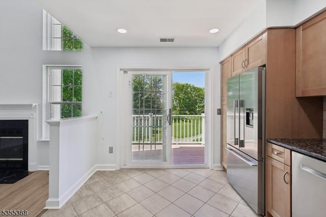 4703 Patterson St, Bridgewater Twp, NJ 08807 - kitchen featuring stainless steel appliances, dark stone countertops, baseboards, and light tile patterned floors