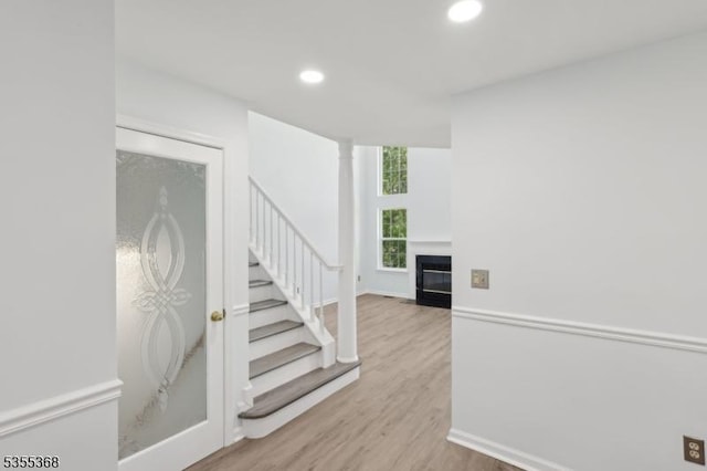 4703 Patterson St, Bridgewater Twp, NJ 08807 - stairs featuring recessed lighting, wood finished floors, a fireplace with flush hearth, and baseboards