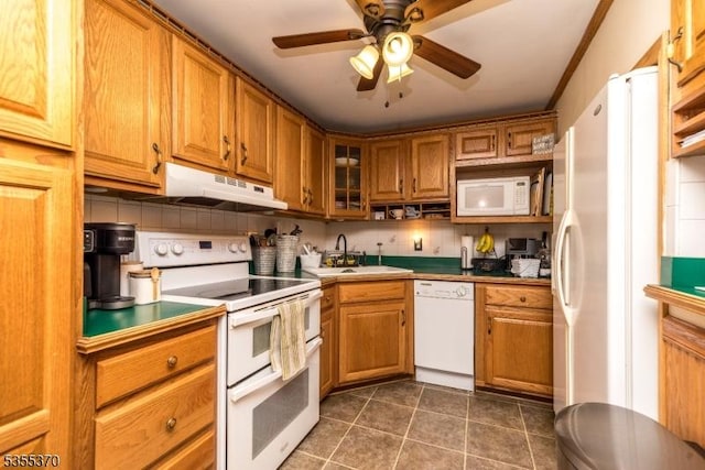 kitchen featuring white appliances, a sink, under cabinet range hood, and brown cabinets
