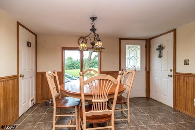 dining area with wainscoting, dark tile patterned floors, plenty of natural light, and a chandelier