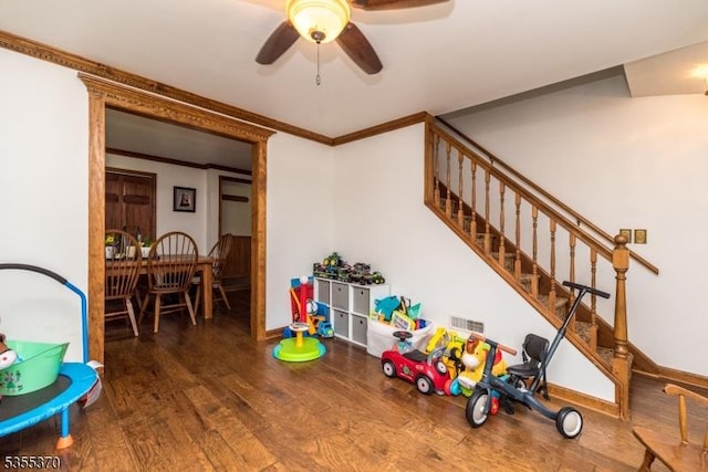 game room with ornamental molding, a ceiling fan, wood finished floors, and baseboards