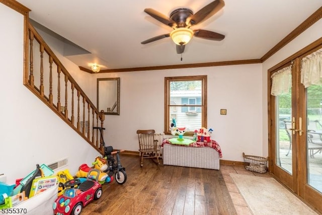 playroom with wood-type flooring, plenty of natural light, baseboards, and ornamental molding