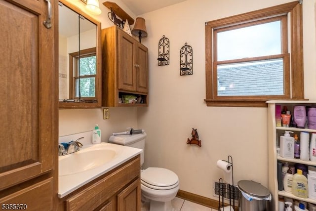 bathroom featuring toilet, vanity, tile patterned flooring, and baseboards