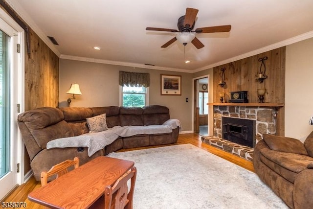 living room with wood finished floors, ceiling fan, ornamental molding, a fireplace, and recessed lighting