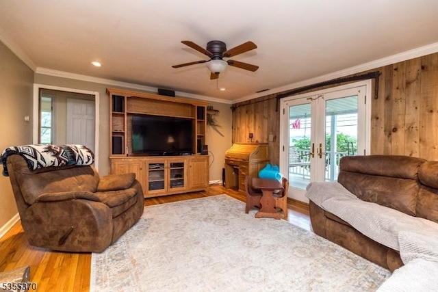 living area featuring crown molding, french doors, a ceiling fan, and wood finished floors