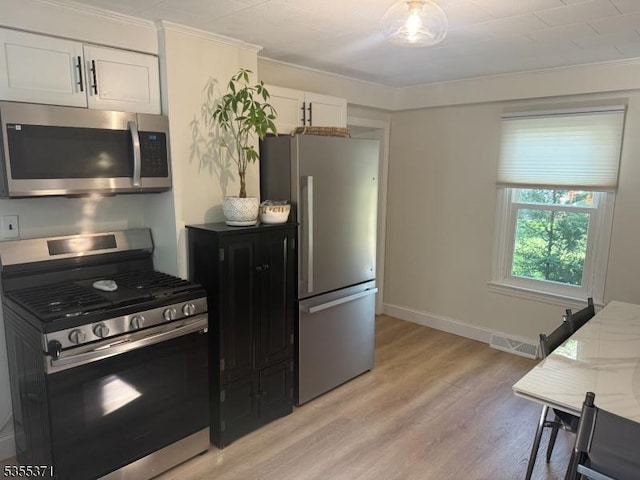 11 Union St, Franklin Twp, NJ 08528 - kitchen with stainless steel appliances, light wood finished floors, white cabinetry, baseboards, and ornamental molding