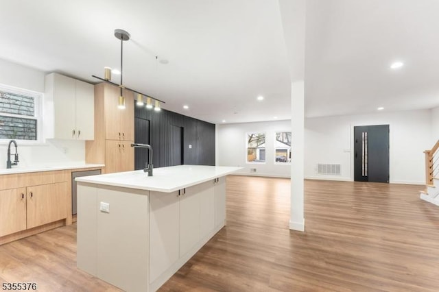 kitchen featuring recessed lighting, open floor plan, light brown cabinets, and dishwasher