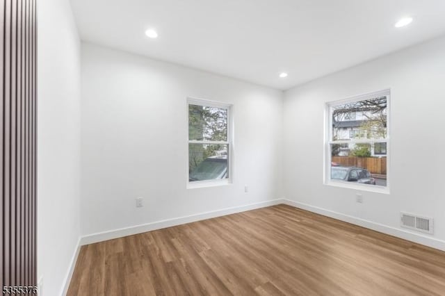 spare room with recessed lighting, baseboards, visible vents, and wood finished floors