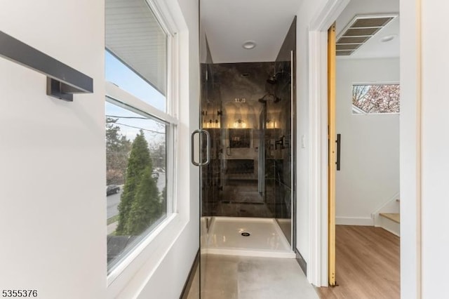 bathroom with baseboards, a shower stall, and visible vents