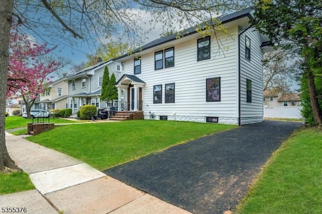 view of front of property featuring a front yard and aphalt driveway