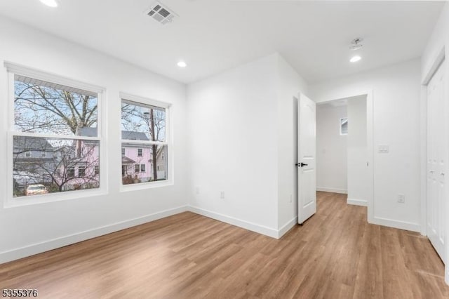 unfurnished room with recessed lighting, baseboards, visible vents, and light wood finished floors