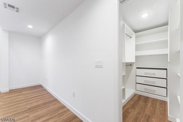 spacious closet featuring wood finished floors and visible vents