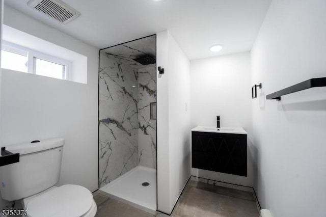 full bath with a marble finish shower, vanity, toilet, and visible vents