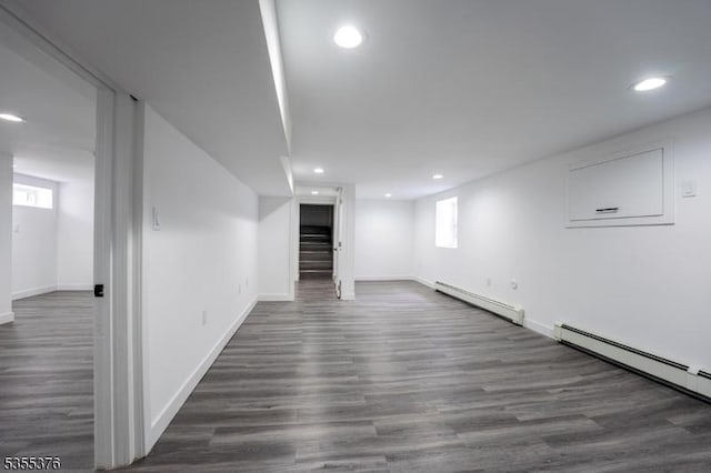 basement with recessed lighting, baseboards, a baseboard heating unit, and stairway