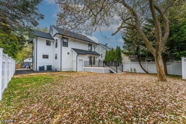 back of property featuring a deck, central AC unit, and a fenced backyard
