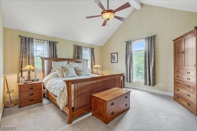 bedroom with high vaulted ceiling, multiple windows, light carpet, baseboards, and beam ceiling