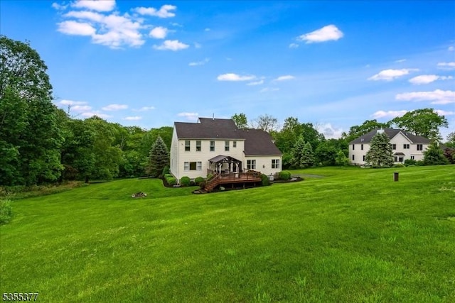 rear view of house featuring a deck and a lawn