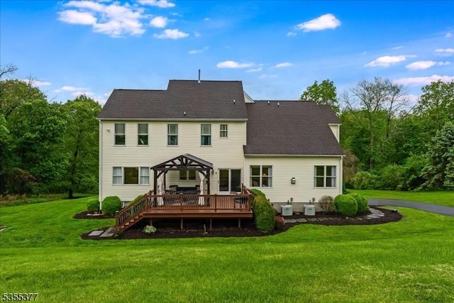 back of house with a deck, a lawn, a gazebo, and roof with shingles