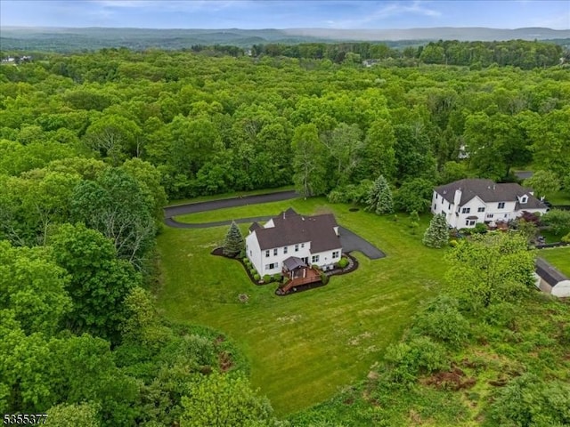 aerial view of property and surrounding area featuring a forest