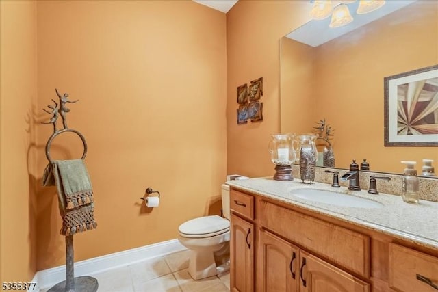 bathroom featuring toilet, vanity, tile patterned floors, and baseboards