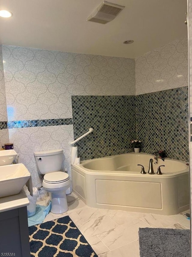 3 Harbor Front Ct Unit 3, Elizabeth City, NJ 07206 - bathroom with toilet, a bath, vanity, tile walls, and marble look tile flooring