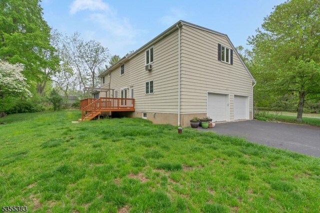 31 Charlotte Dr, Clinton Twp, NJ 08833 - view of side of home with an attached garage, a wooden deck, driveway, and a yard
