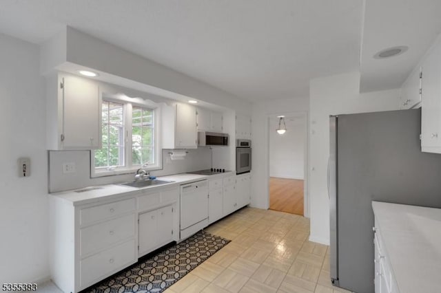 31 Charlotte Dr, Clinton Twp, NJ 08833 - kitchen featuring appliances with stainless steel finishes, a sink, white cabinets, and light countertops