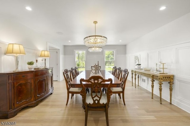 dining area featuring an inviting chandelier, light wood-style floors, a decorative wall, and recessed lighting