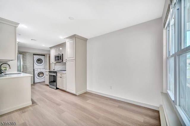 42B Catalpa Plz Unit B, Monroe Twp, NJ 08831 - kitchen featuring stainless steel appliances, stacked washer / dryer, a sink, light countertops, and light wood finished floors