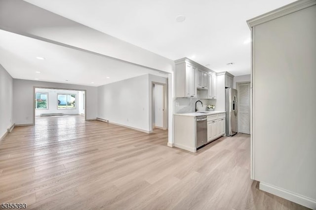42B Catalpa Plz Unit B, Monroe Twp, NJ 08831 - kitchen featuring stainless steel appliances, light countertops, a sink, open floor plan, and light wood-style flooring