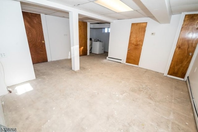 below grade area with washer / dryer and a baseboard heating unit
