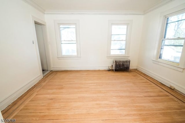 unfurnished room with crown molding, plenty of natural light, and radiator