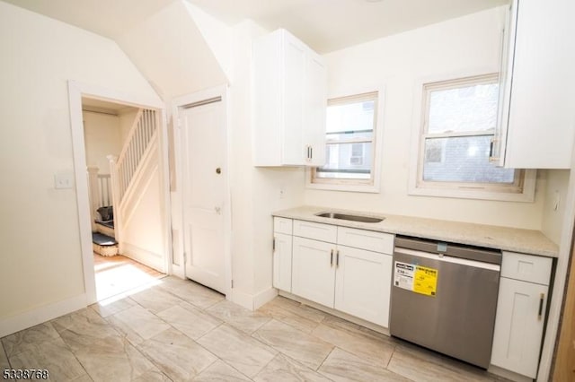 kitchen with dishwasher, a sink, baseboards, marble finish floor, and white cabinetry