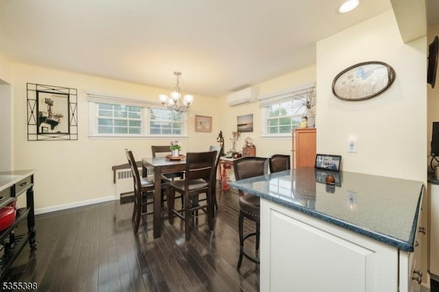 dining room featuring a chandelier, dark wood-type flooring, a wall mounted air conditioner, and baseboards