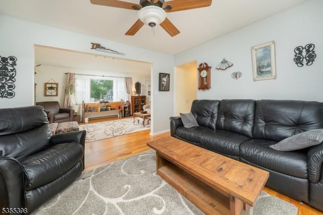 living room with wood finished floors and ceiling fan