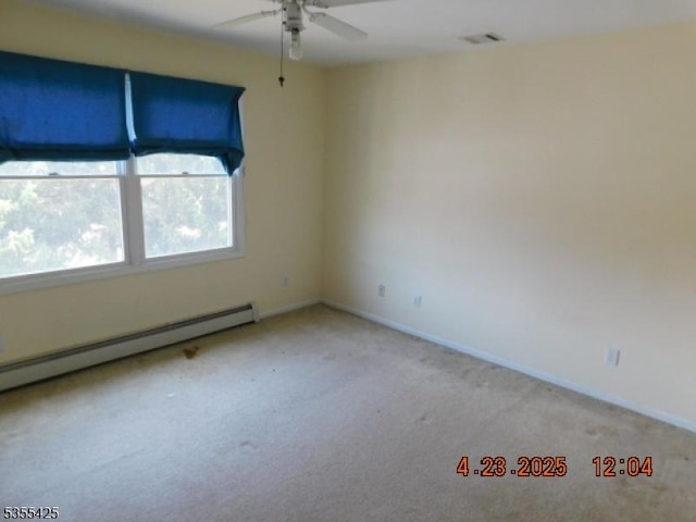 carpeted empty room with visible vents, baseboards, ceiling fan, and baseboard heating