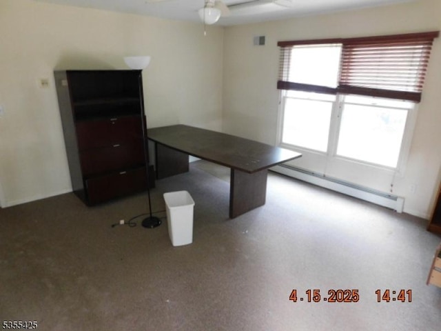 unfurnished office featuring ceiling fan, a baseboard heating unit, and visible vents