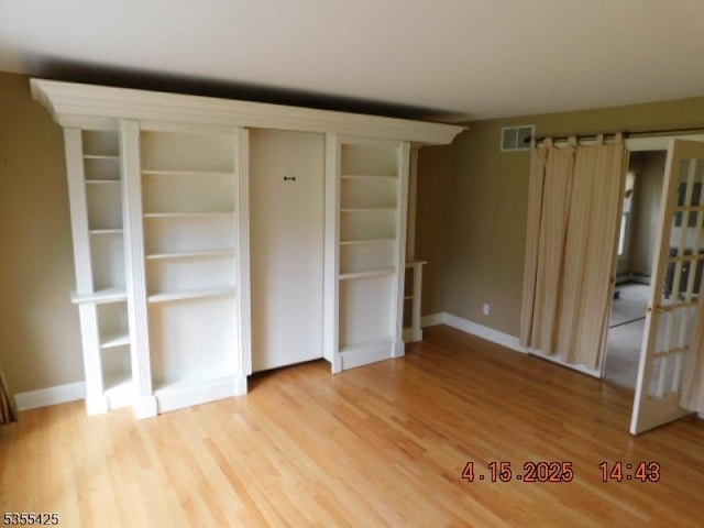unfurnished bedroom with baseboards, visible vents, and light wood-style floors