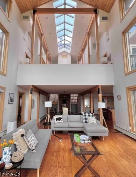 living room with high vaulted ceiling and wood finished floors