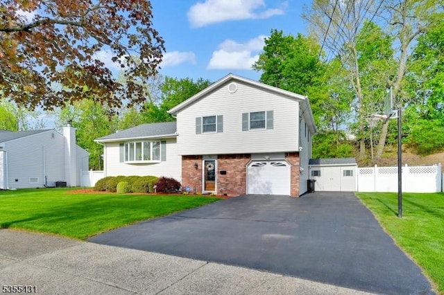 split level home featuring brick siding, driveway, a garage, and central AC