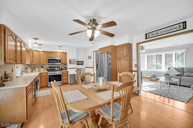 dining space with ceiling fan and light wood finished floors
