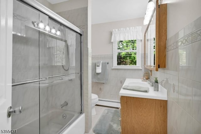 bathroom featuring a baseboard radiator, tile walls, vanity, toilet, and shower / bath combination with glass door