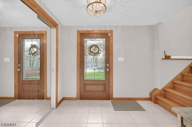entryway with plenty of natural light, baseboards, and light tile patterned floors