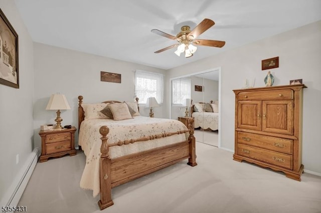 bedroom with a baseboard heating unit, light colored carpet, a ceiling fan, and baseboards