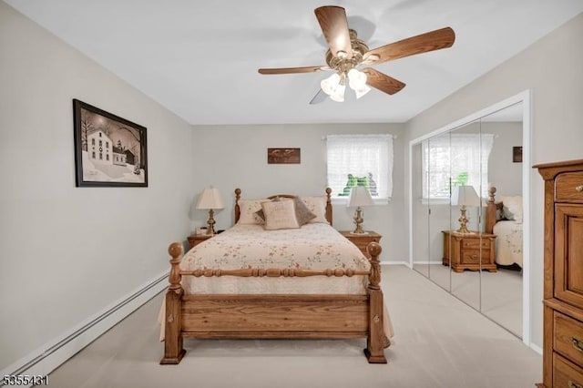 bedroom featuring a baseboard heating unit, a closet, ceiling fan, and baseboards