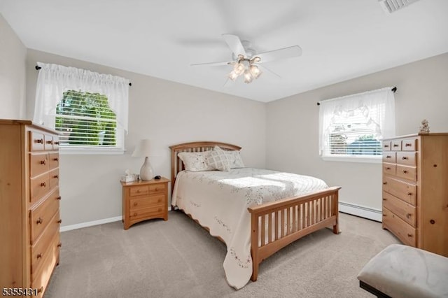 bedroom with multiple windows, a baseboard heating unit, light carpet, and ceiling fan