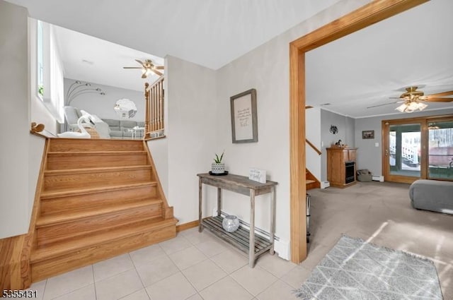 staircase featuring a ceiling fan, baseboards, and tile patterned floors